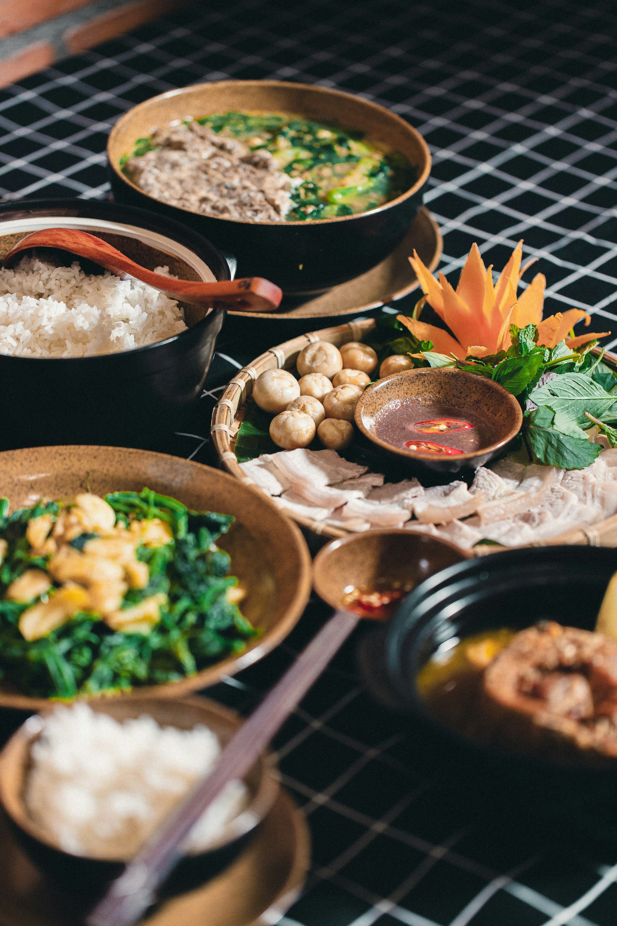 Mâm cơm Việt với các món dùng chung, rau và bát cơm